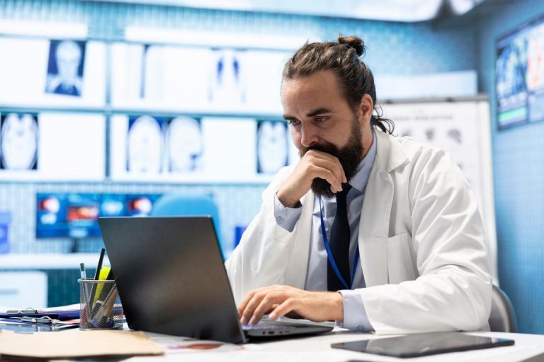 General practitioner working with hospital records and test results to find the diagnosis in his cabinet, examining x rays and reports. Doctor doing research for disease prevention and treatment.